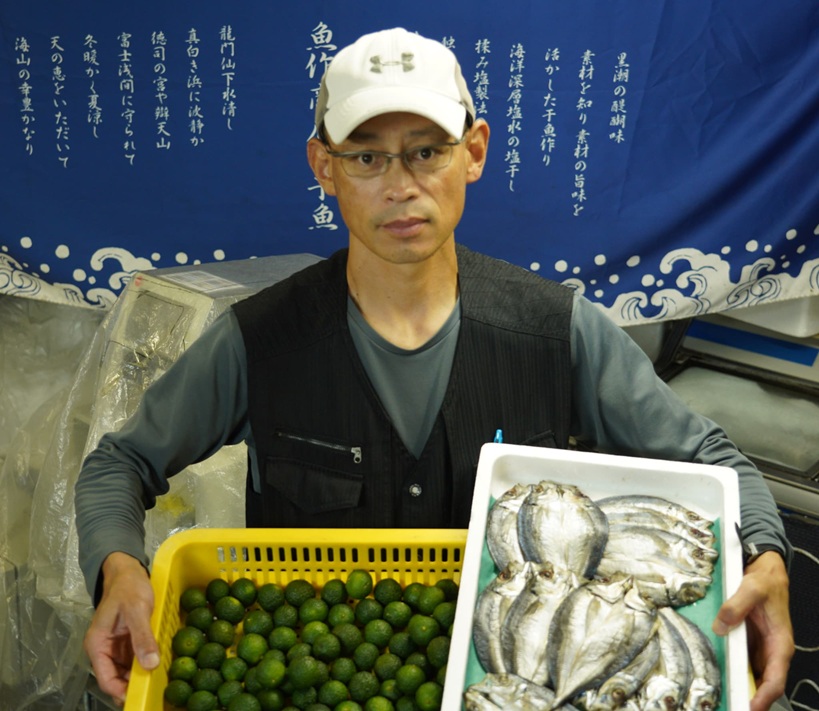 果物と絵を持つ男性の真剣な表情